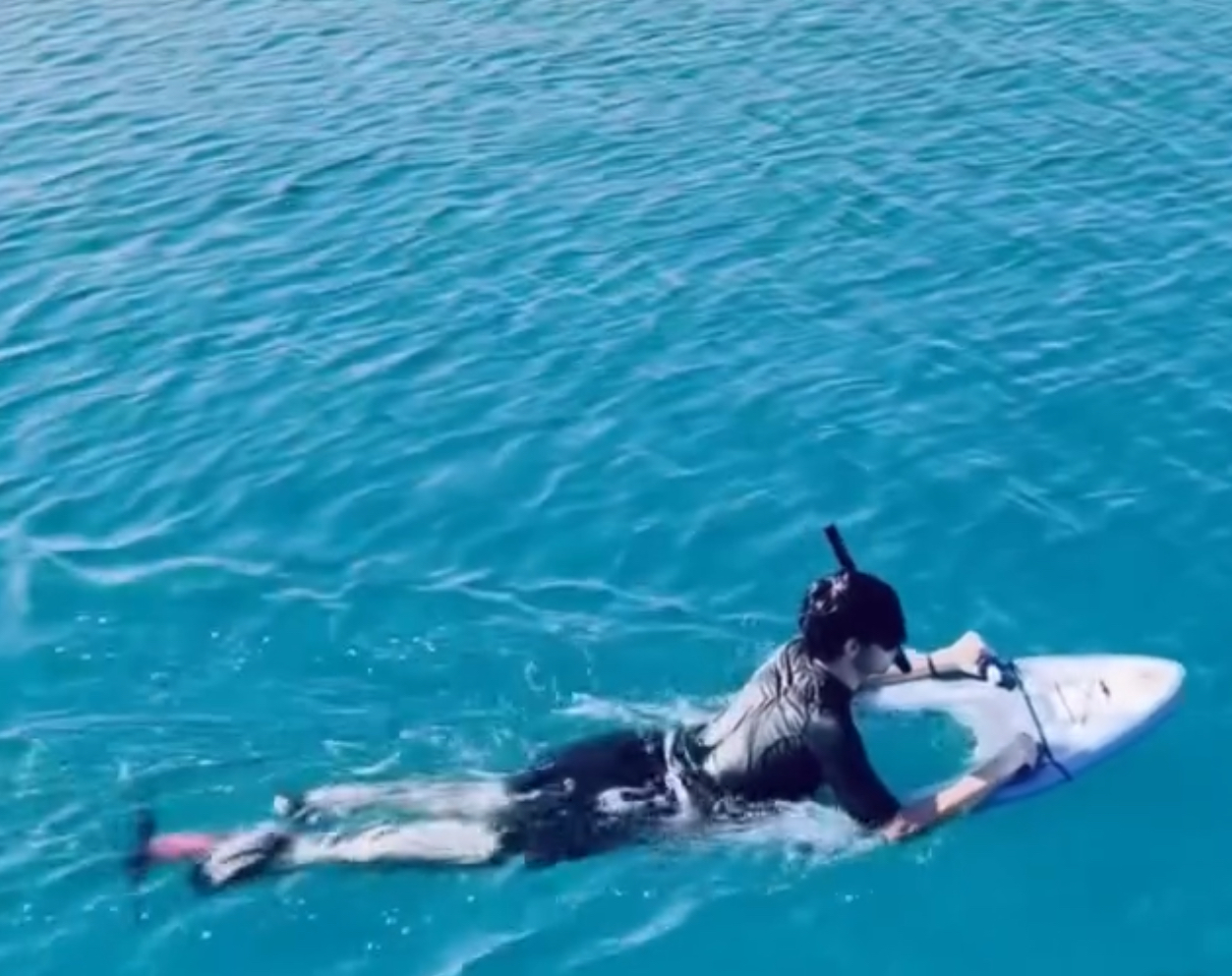 Adventure seeker riding sea board in turquoise waters