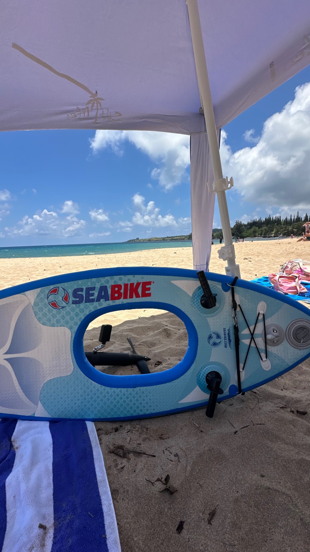 Maui Sea Board snorkeling board staged on the sand beneath a shade canopy at the beach, ready for a concierge delivery drop-off